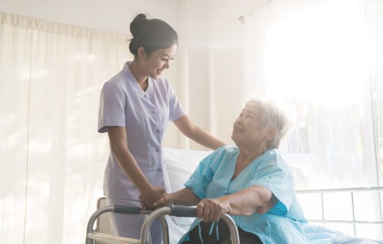 Asian young nurse supporting elderly patient disabled woman in using walker in hospital. Elderly patient care concept.. Asian young nurse supporting elderly patient disabled woman in using walker in hospital. Elderly patient care concept.